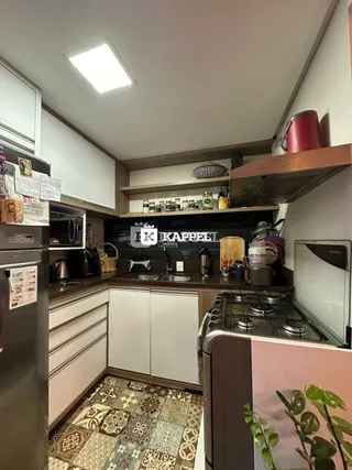 Foto de uma cozinha com armários superiores e bancada.