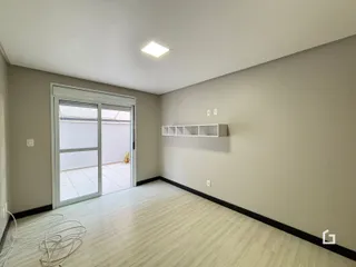 Sala de estar com porta de vidro abrindo para o exterior.