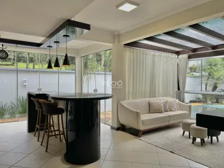 Sala de estar com mesa de jantar e vista para o jardim de uma residência em Lajeado.