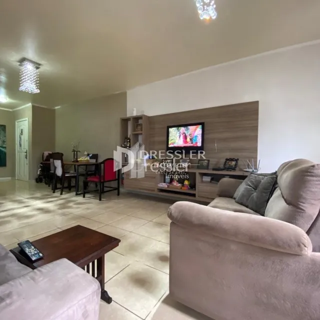 Sala de estar com sofá e televisão em ambiente claro.
