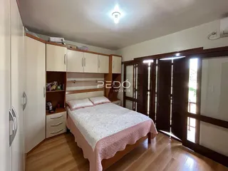 Quarto com armários embutidos e cama de casal em madeira.