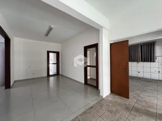 Espaço interno com paredes brancas e piso de cerâmica.