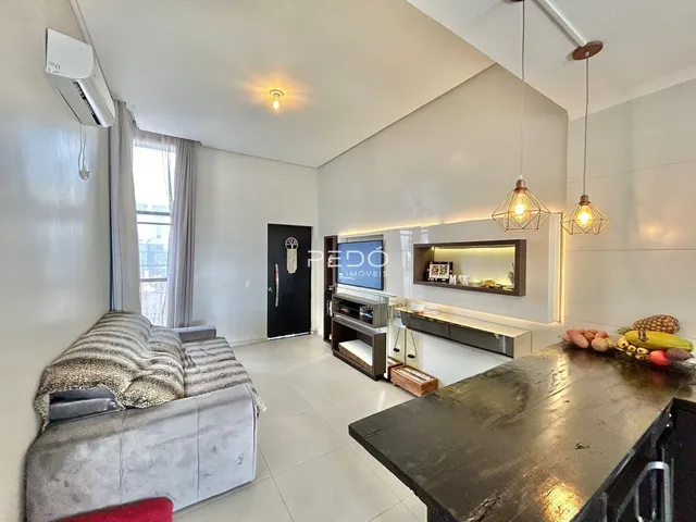Sala de estar moderna com grandes janelas e piso claro.