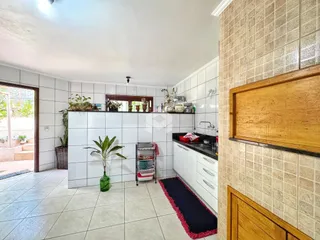 A cozinha apresenta piso de cerâmica e paredes brancas.