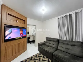 Sala de estar com sofá e painel de TV em um imóvel.