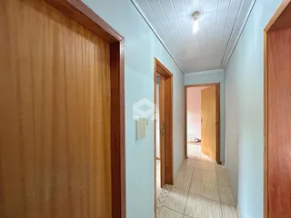 Hall de entrada com portas de madeira e piso de cerâmica.