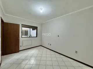 Ambiente interno de uma sala com piso de cerâmica e parede branca.