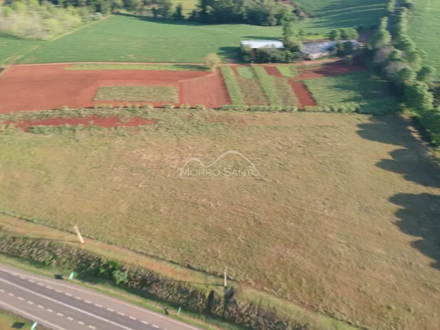 Vista aérea de uma propriedade rural com campos abertos e vegetação.