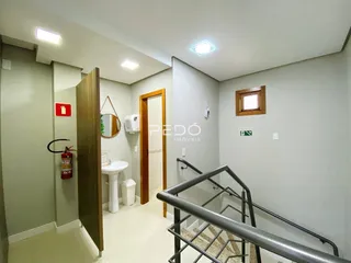 Hall de entrada com banheiro e escadaria em um imóvel no Brasil.
