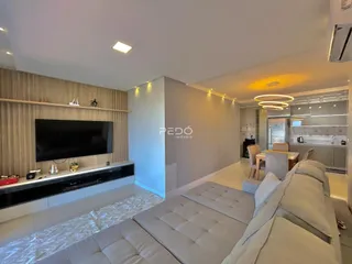 Sala de estar moderna com sofá e televisão em um imóvel no Brasil.