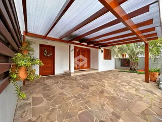 Pátio externo com piso de pedra e estrutura de madeira.