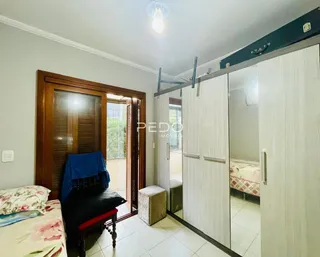 Foto de um quarto com cama e armário espelhado em uma residência.