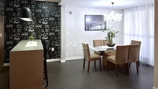 Sala de jantar com mesa e cadeiras em um ambiente interno.
