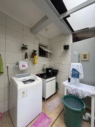 Banheiro com máquina de lavar e pia.