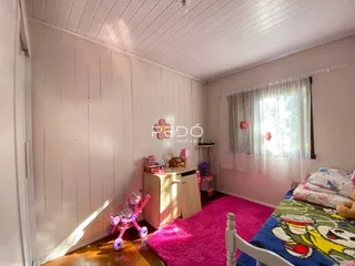 Quarto com paredes de madeira e decoração infantil em Lajeado.