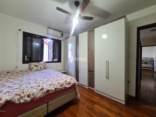 Quarto com cama e armários embutidos em um ambiente com piso de madeira.