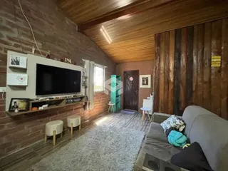 Sala de estar com paredes de tijolo aparente e teto de madeira.