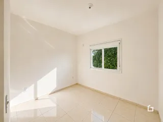 Foto de um cômodo interno com paredes brancas e piso de cerâmica.
