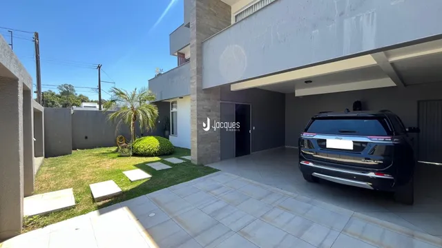 Fachada de uma residência moderna em Lajeado, Brasil, com jardim e área externa pavimentada.