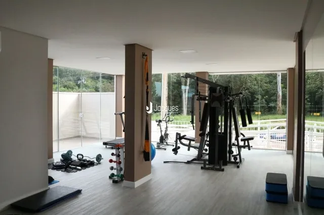 Espaço interno com equipamentos de ginástica em um imóvel.