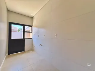 Corredor interno com paredes brancas e piso claro.