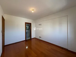 Sala de estar com piso de madeira e paredes brancas.