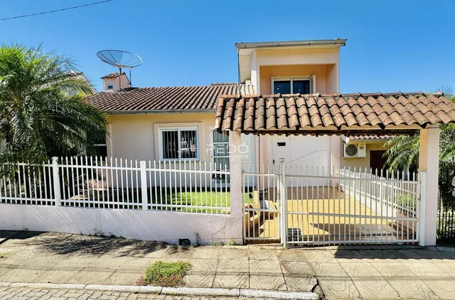 Vista da fachada de uma casa em Lajeado, Brasil, com cerca e portão brancos.