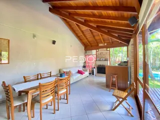 Uma foto de uma sala de jantar com piso de madeira e teto de madeira.