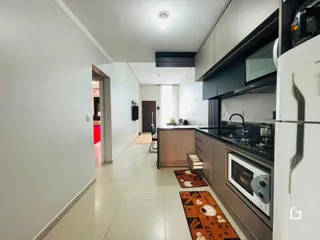 Corredor interno de uma residência com cozinha moderna.