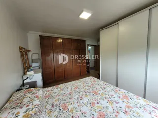 Quarto com armários de madeira e cama decorada.