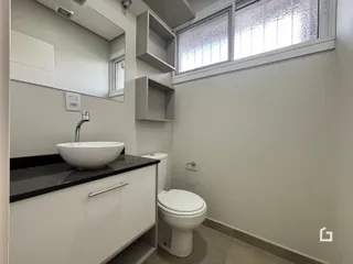 Foto do interior de um banheiro com pia e vaso sanitário.