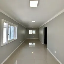 Corredor interno com paredes brancas e piso claro.