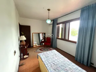 Quarto interno com parede branca e piso de carpete marrom.