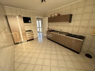 Foto de uma cozinha com armários de madeira e piso cerâmico.