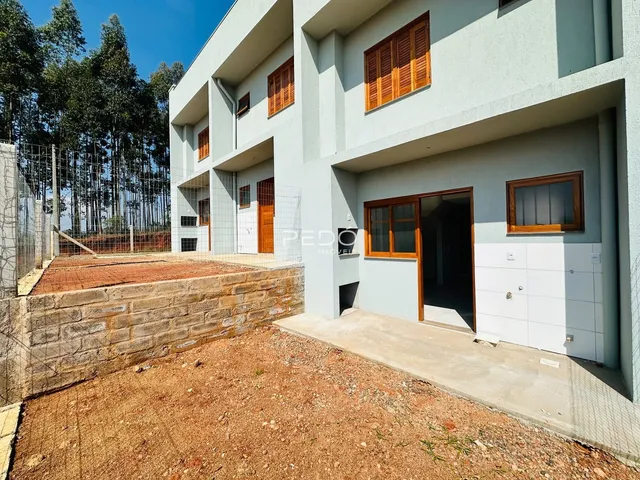 Fachada externa de uma residência em Lajeado, Brasil, com muro de contenção de pedra.