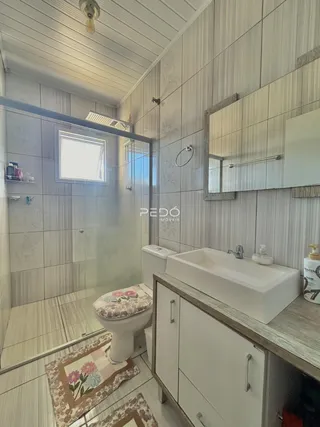 Foto de um banheiro com revestimento de azulejos e bancada de madeira.
