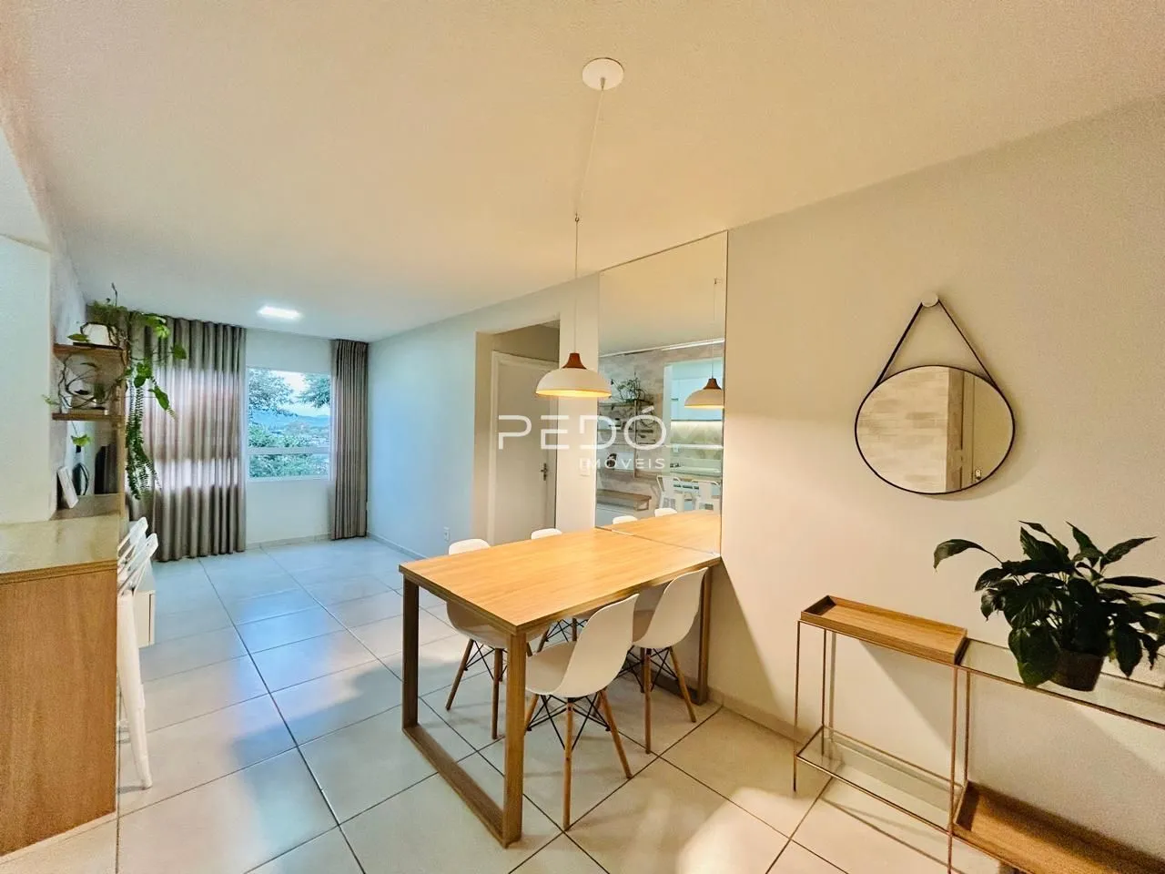 Ambiente interno de uma sala com piso de cerâmica e mesa de madeira.