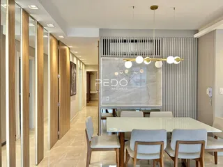 Sala de jantar moderna com mesa de madeira e cadeiras claras.