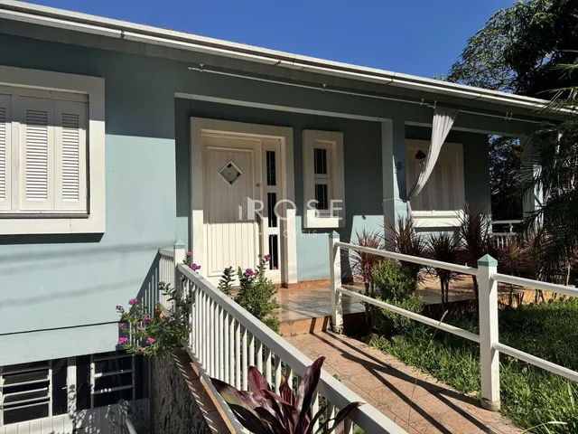 Fachada de uma residência em Lajeado, Brasil com detalhes de madeira e pintura azul clara.