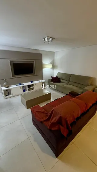 Sala de estar com sofá e televisão em um imóvel no Brasil.