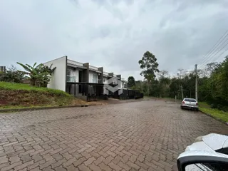 Fachada de uma residência moderna em Lajeado, Brasil, com área pavimentada na frente.