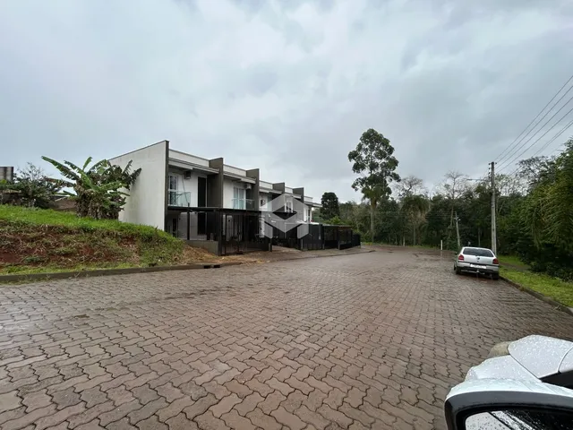 Fachada de uma residência moderna em Lajeado, Brasil, com área pavimentada na frente.