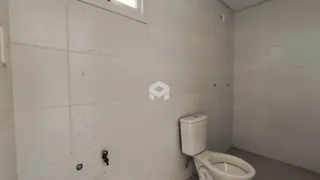 Banheiro com paredes brancas e azulejos.