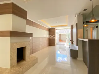 Sala de estar moderna com parede de destaque e lareira em um imóvel no Brasil.