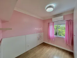 Quarto com paredes rosa e piso de madeira.