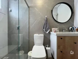 Foto de um banheiro moderno com box de vidro e revestimento de mármore.