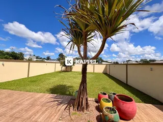 Vista de um jardim com deck de madeira e gramado em uma propriedade em Lajeado.
