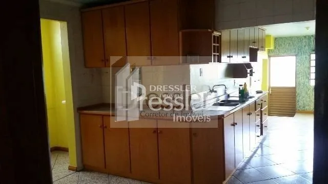 Vista interna de uma cozinha com armários de madeira.