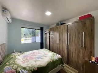 Quarto com cama e guarda-roupa de madeira em um imóvel no Brasil.