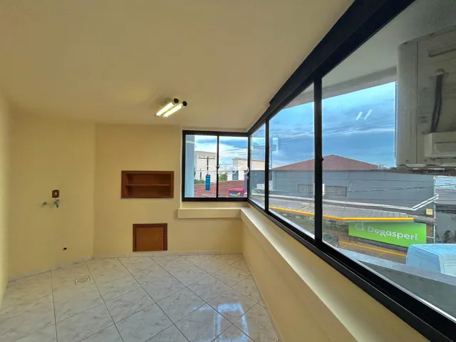 Ambiente interno de uma sala com piso de cerâmica e grandes janelas.